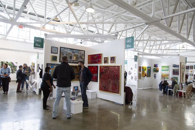 People looking at art in a large, spacious room.